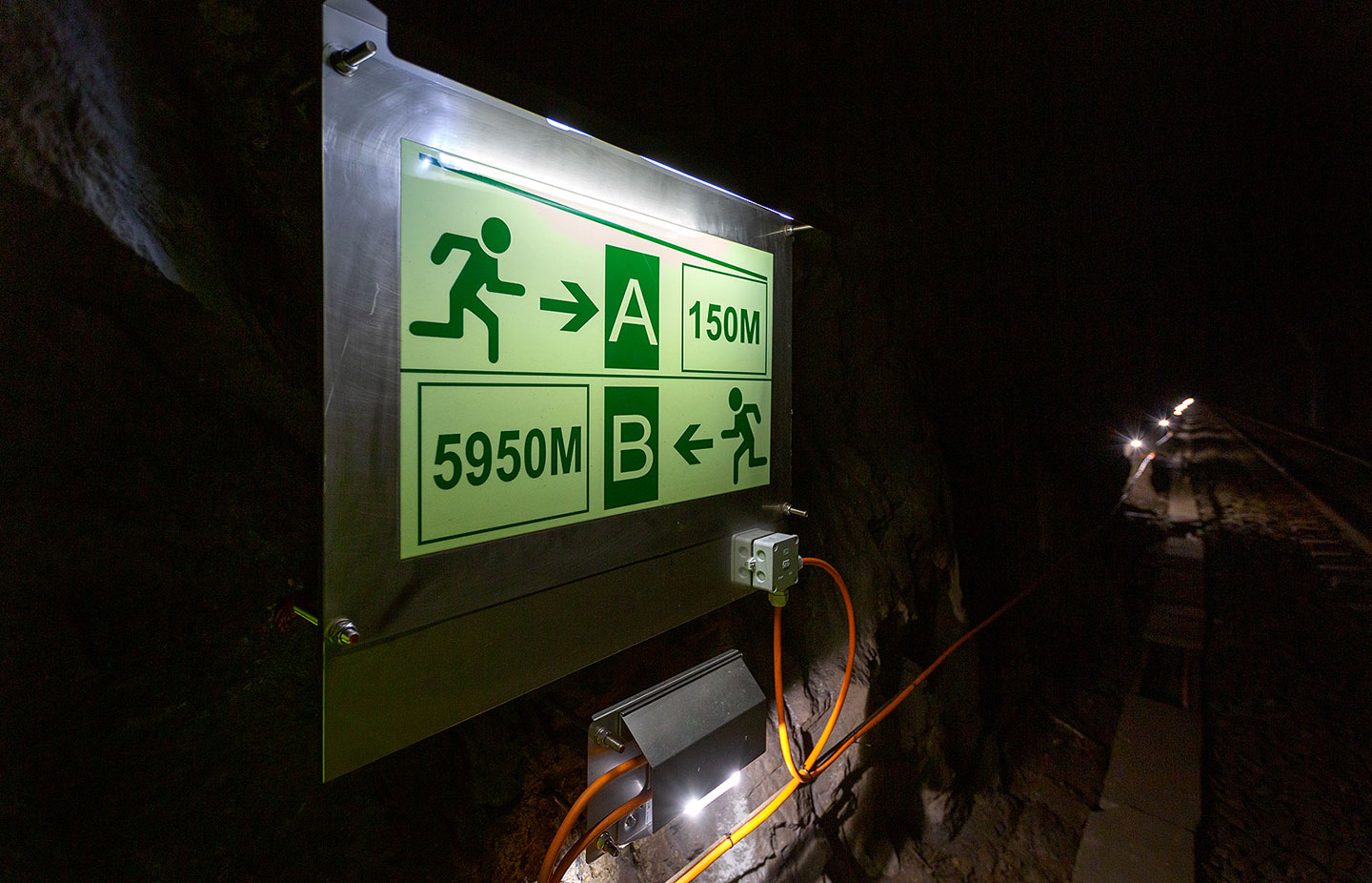 Nærbilde av skilt for merking av av rømningsvei i togtunnel